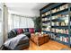 Charming living room with custom shelves, leather couch, and an exposed brick wall at 4968 Alcott St, Denver, CO 80221
