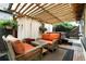 Inviting patio area featuring a hot tub, comfortable wicker furniture, and pergola with decorative lighting at 4968 Alcott St, Denver, CO 80221