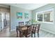 Bright dining area with a wooden table set for four, next to a large window at 9843 Rosalee Peak St, Littleton, CO 80125