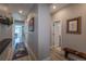 Long, neutral-toned hallway with wood-look flooring and wall art, leading to a brightly lit living area at 9843 Rosalee Peak St, Littleton, CO 80125