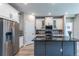 Elegant kitchen with a central island, stainless steel refrigerator, and a modern backsplash at 9843 Rosalee Peak St, Littleton, CO 80125