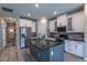 Modern kitchen featuring a large island, stainless steel appliances, and stylish white cabinetry with dark countertops at 9843 Rosalee Peak St, Littleton, CO 80125