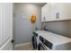 Functional laundry room with a washer, dryer, and storage cabinets at 9843 Rosalee Peak St, Littleton, CO 80125