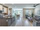 Open-concept kitchen, dining, and living area with modern finishes, wood floors, and abundant natural light at 9843 Rosalee Peak St, Littleton, CO 80125