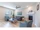 Comfortable living room with modern furnishings, a fireplace, and ample natural light from a large window at 9843 Rosalee Peak St, Littleton, CO 80125