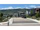 Scenic street view of suburban homes with mountain backdrop, manicured landscaping, and neighborhood charm at 9843 Rosalee Peak St, Littleton, CO 80125