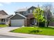 Exterior view of the home featuring a brick facade, mature trees, and a well-manicured lawn at 19716 Glendale Ln, Parker, CO 80134