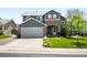 Charming two-story home with a well-manicured lawn, a gray exterior, and brick accent at 19716 Glendale Ln, Parker, CO 80134