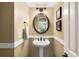Charming powder room with pedestal sink, decorative mirror, and elegant wall trim at 19716 Glendale Ln, Parker, CO 80134