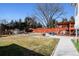 Large backyard featuring a patio area with seating, mature trees, and a wooden fence at 6409 Brentwood St, Arvada, CO 80004