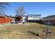 Expansive backyard with a disc golf basket, patio area, and mature trees at 6409 Brentwood St, Arvada, CO 80004