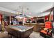 Spacious basement with a pool table, arcade games, bar, and comfortable seating area at 6409 Brentwood St, Arvada, CO 80004