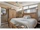 Comfortable bedroom featuring natural light, a ceiling fan, a wooden bed frame, and built-in storage at 6409 Brentwood St, Arvada, CO 80004