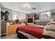 Bedroom with a red bedspread, light walls, dresser, and window at 6409 Brentwood St, Arvada, CO 80004