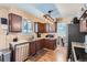 Kitchen with dark brown cabinets, stainless steel appliances, and a view of the dining area at 15064 E Floyd Ave, Aurora, CO 80014