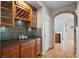 Stylish bar area with custom cabinetry, wine storage, and mosaic backsplash at 13804 Quail Ridge Dr, Broomfield, CO 80020
