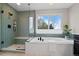 Updated bathroom with a glass-enclosed shower, soaking tub and large window for ample natural light at 13804 Quail Ridge Dr, Broomfield, CO 80020