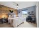 Cozy bedroom featuring a wood accent wall, comfortable bed, and adjacent desk area at 13804 Quail Ridge Dr, Broomfield, CO 80020