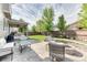 Well-manicured backyard featuring a fire pit area, outdoor seating, covered patio, and privacy fence at 15389 W 50Th Dr, Golden, CO 80403