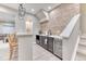 Close-up of basement bar featuring brick accents, quartz countertops, seating, and built-in mini fridge at 15389 W 50Th Dr, Golden, CO 80403