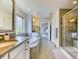 This bathroom features double vanities, an oversized soaking tub, and a walk-in shower with neutral tiling at 15389 W 50Th Dr, Golden, CO 80403