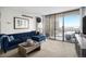 Bright living room featuring a comfortable blue sofa, neutral carpet, and large sliding glass doors at 1020 15Th St # 9N, Denver, CO 80202