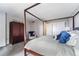 Cozy bedroom featuring a four-poster bed, closet, accent chair, and soft lighting at 1020 15Th St # 9N, Denver, CO 80202