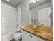 Bathroom featuring modern vessel sink, granite countertop, and tub with white tile surround at 10241 Bellwether Ln, Lone Tree, CO 80124
