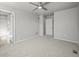 Spacious bedroom with ceiling fan, neutral carpet, and entry to en suite bathroom at 10241 Bellwether Ln, Lone Tree, CO 80124