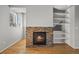 Cozy fireplace featuring beautiful stone surround, built-in shelving, hardwood flooring and natural light at 10241 Bellwether Ln, Lone Tree, CO 80124