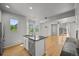 Open kitchen featuring stainless appliances, island, and hardwood floors flowing into living space at 10241 Bellwether Ln, Lone Tree, CO 80124
