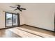Sunny bedroom with hardwood floors, modern ceiling fan, and sliding glass door to a private balcony at 1660 Utica St, Denver, CO 80204