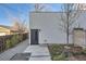 Side view of a modern townhome with a gray door, minimalist landscaping, and a sleek aesthetic at 1660 Utica St, Denver, CO 80204