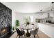 Bright dining area featuring a stone fireplace, round table, and sliding glass doors to the backyard at 558 S Field Ct, Lakewood, CO 80226