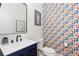 Chic powder room featuring a vanity with sleek fixtures and colorful, patterned wallpaper at 9158 Martin Luther King Blvd, Denver, CO 80238