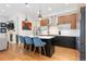 Modern kitchen island featuring seating, sleek black cabinets, and stainless appliances at 9158 Martin Luther King Blvd, Denver, CO 80238