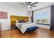 Comfortable main bedroom featuring a plush bed, ample natural light, and a stylish ceiling fan at 9158 Martin Luther King Blvd, Denver, CO 80238