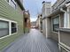 View of the long deck area between townhouses, with green siding, and gray decking to enjoy on sunny days at 3025 Broadway St # 17, Boulder, CO 80304