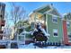 Green two-story home featuring red brick accents, a snow-covered yard, and a balcony at 3025 Broadway St # 17, Boulder, CO 80304