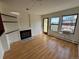 Sunlit living room with wood floors, fireplace, built in shelves, and a balcony at 3025 Broadway St # 17, Boulder, CO 80304