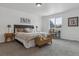 A modern bedroom featuring large window, modern lamps, and a large comfy bed at 5207 Dudley St, Arvada, CO 80002