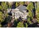 Stunning aerial view of a sprawling home nestled among lush greenery and mature trees at 108 Castle Pines N Dr, Castle Rock, CO 80108