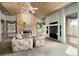 Cozy living room with a stone fireplace, wood paneled ceiling and large windows at 108 Castle Pines N Dr, Castle Rock, CO 80108