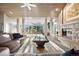 Bright living room with stone fireplace, large windows and a comfortable seating area at 108 Castle Pines N Dr, Castle Rock, CO 80108