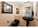 Stylish powder room featuring a modern black sink and toilet, complemented by tasteful artwork and unique design elements at 108 Castle Pines N Dr, Castle Rock, CO 80108