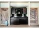 Stylish wet bar area with sleek black cabinetry, ample counter space and mini-refrigerator at 108 Castle Pines N Dr, Castle Rock, CO 80108