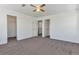 Large bedroom with neutral carpet, white walls, ceiling fan, and multiple doors at 5798 Biscay St, Denver, CO 80249