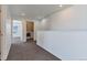 Bright hallway with neutral carpet, white walls, and doors leading to a laundry area and other rooms at 5798 Biscay St, Denver, CO 80249