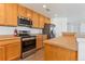 Kitchen area features stainless steel appliances, wooden cabinets, and ample countertop space at 5798 Biscay St, Denver, CO 80249