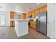 The kitchen features stainless steel appliances, wooden cabinets, tile floors, and a center island at 5798 Biscay St, Denver, CO 80249